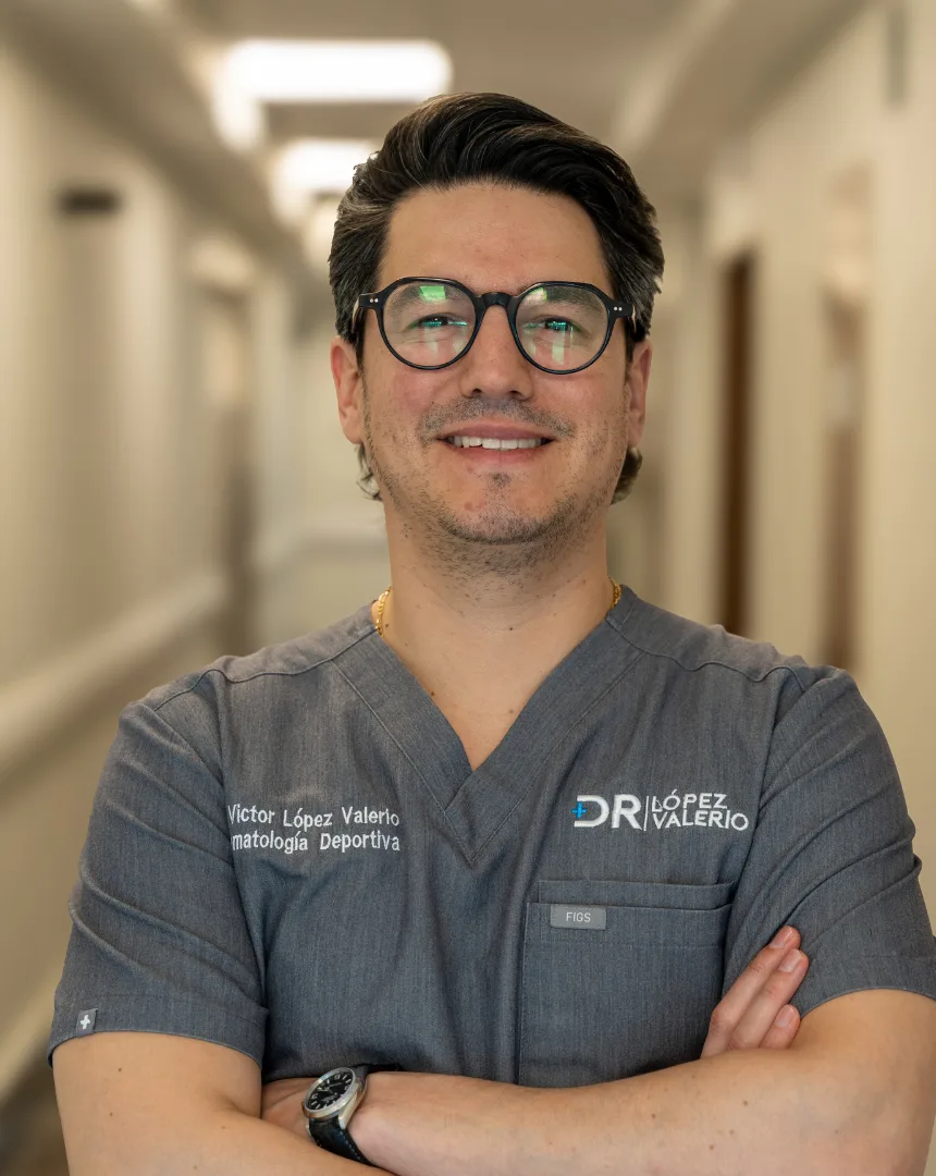 Portrait of Dr. Víctor López Valerio, orthopedic and trauma surgeon, in gray scrubs with his arms crossed